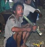 A man with his home made pipe for smoking opium.