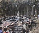 A statue of Buddha looks on at charred remains